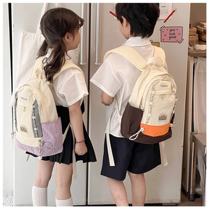 Détail de sacs à dos enfant bicolores avec cordon et logo TOCHASO sur tissu en nylon