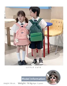Pink and green lightweight nylon toddler backpacks shown on kids in a modern room