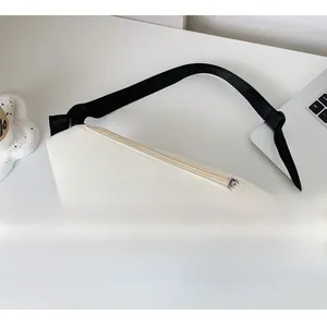 Dettaglio della borsa a tracolla in tela crema con cinturino regolabile e zip