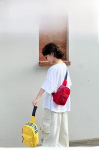 Detail of red and yellow canvas chest bags featuring DUDING text and zipper pockets