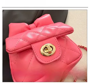 Vue macro détaillée du fermoir doré rotatif et de la texture matelassée rose du mini sac