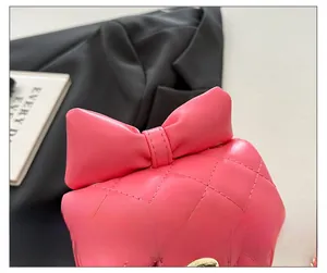 Détail d'un sac fille rose vif matelassé avec nœud assorti et fermoir en métal doré