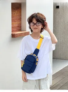 Detail of navy canvas kids chest bag with yellow strap and pudding text print