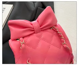 Détail des coutures matelassées roses et du nœud sur le mini sac à chaîne pour filles