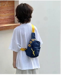 Close-up of kids navy blue crossbody chest bag with bright yellow contrast straps and zipper