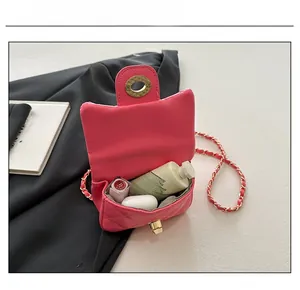 Capacité interne du sac bandoulière rose matelassé avec rouge à lèvres et écouteurs