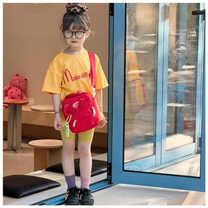Kids streetwear style featuring a bright yellow t-shirt and red sporty crossbody bag