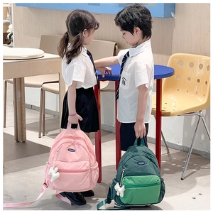 Kids backpack showing pink and green nylon school bags with cute cartoon ornaments
