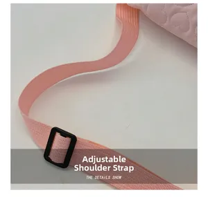 Détail de la bandoulière rose réglable avec boucle noire sur le sac de poitrine matelassé