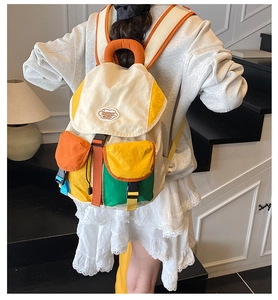 Detail of multi-color patchwork nylon backpack with buckle closure and fashion labels