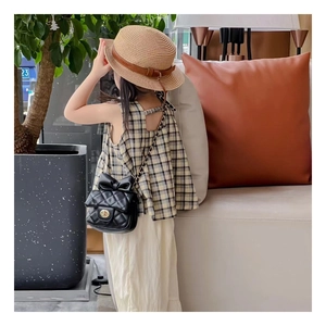 Détail du mini sac matelassé noir pour fille avec nœud papillon et chaîne dorée