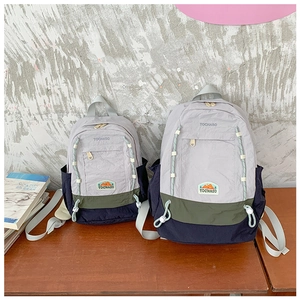 Détail de sacs à dos en nylon bicolore en grandes et petites tailles avec poches latérales