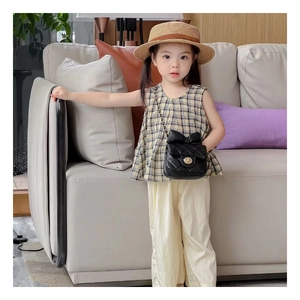 Mini sac bandoulière matelassé noir avec nœud et chaîne sur une tenue de fille chic