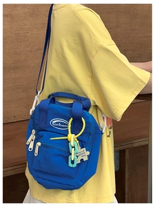 Close-up of bright blue crossbody kids bag with colorful chains and puzzle pendant detail