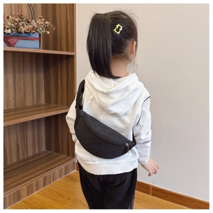 Vue de dos d'une fille portant un sac de poitrine noir matelassé avec motifs cœurs