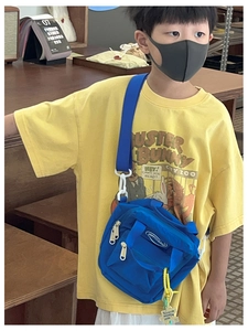 Detail of royal blue canvas crossbody bag for kids featuring dual zippers and adjustable strap