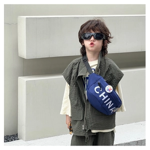 Dettaglio del borsello da petto per bambini con scritta CHINA e logo colorato su abito casual