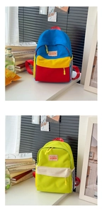 Dettaglio di zaini in tela color-block con strisce laterali e logo alla moda