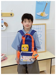 Detail of cute panda cartoon kids backpack with orange mesh pocket and airplane charm