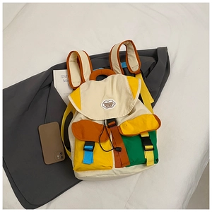 Detail view of colorful canvas backpack with buckle closure and drawstring on grey blazer