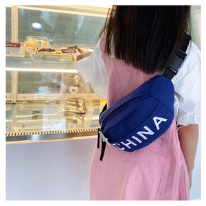 Vista posteriore di un bambino con borsa pettorale in tela blu e scritte CHINA bianche
