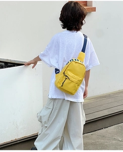 Detailed view of yellow canvas kids crossbody bag with blue adjustable strap