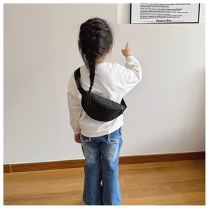 Détail de la texture nuage matelassée noire sur le sac de poitrine pour enfant avec sangle