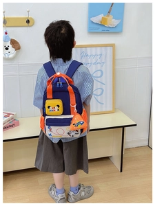 Rear view of a child wearing the blue cartoon panda backpack with airplane route details