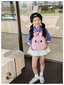 Pink toddler backpack featuring cartoon rabbit ears worn by a child in outdoor setting