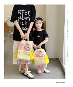 Detail showing two sizes of contrast color backpacks with a pink rabbit pendant