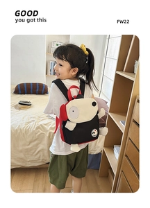 Kleinkind zeigt die Seitenansicht eines süßen Welpen-Rucksacks im Kinderzimmer