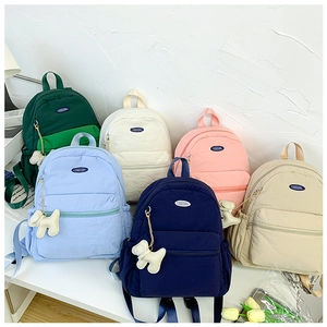 Close-up of waterproof nylon backpacks in multiple colors with cute dog charms