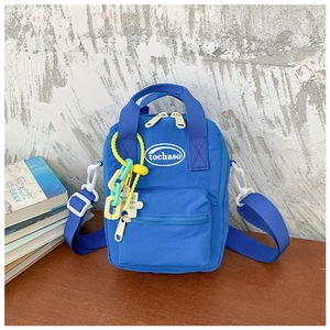 Detail of royal blue mini bag with colorful chain pendant and adjustable strap