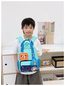 Detail of mint green school backpack with cartoon panda print and aircraft pendant