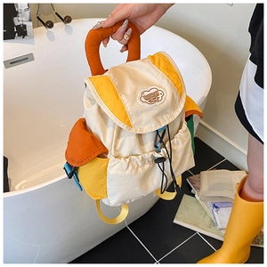 Detail of multi-color waterproof nylon backpack with orange circular handle and fashion patch