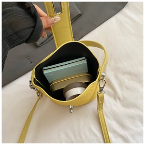 Top view of yellow bucket bag interior showing spacious capacity and woven texture detail