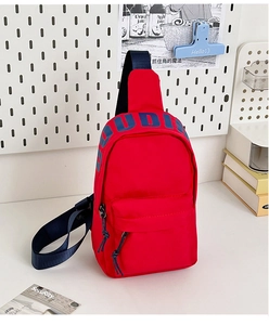 Macro shot of durable red nylon chest bag featuring navy UDI print and zip details