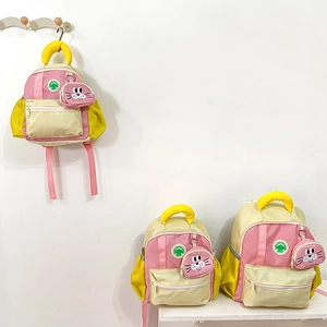 Three sizes of colorful kids backpacks in yellow and pink with cute bunny pendant