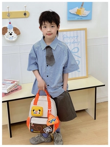 Detail view of cream and brown toddler backpack with cute panda pouch and orange accents