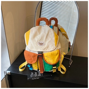Detail view of colorful nylon backpack with contrast panels and orange ring handle