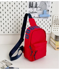 Detail view of red nylon crossbody chest bag with adjustable strap and blue logo text
