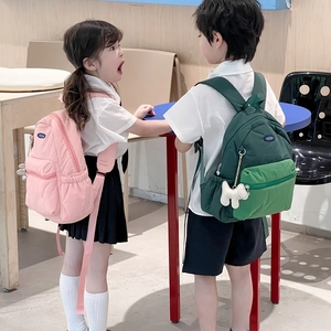 Pink and green ergonomic school backpacks for kids with cute plush charms on straps
