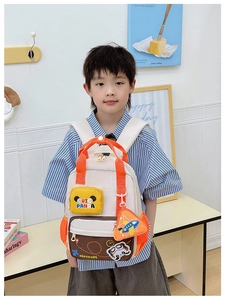Detailed view of child wearing cartoon airplane backpack with orange strap accents