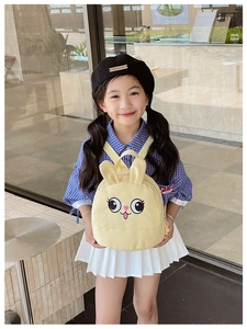 Detailed shot of yellow bunny backpack for kids with 3D ears in a boutique setting