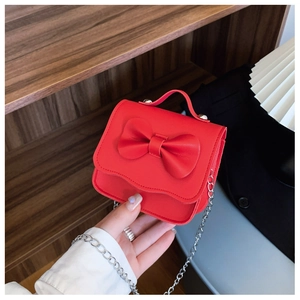 Detailed view of red mini crossbody bag with cute bow and scalloped edge detail
