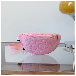 Détail du sac de poitrine rose avec matelassage en cœur et texture métallique fine