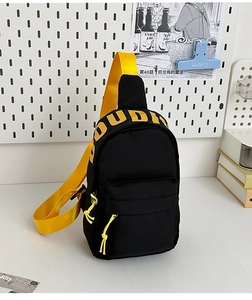 Detail of trendy black and yellow crossbody bag with bold lettering and adjustable strap