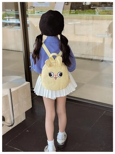 Toddler wearing a cute yellow cartoon bunny backpack in a modern indoor setting
