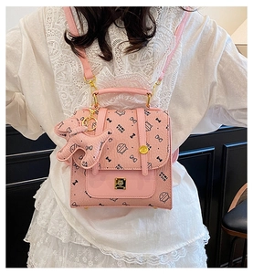 Sac à dos rose avec imprimés de chats et pendentif éléphant vu de l'arrière porté