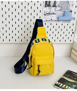 Detail of a bright yellow kids' crossbody bag with UDI logo and blue adjustable strap